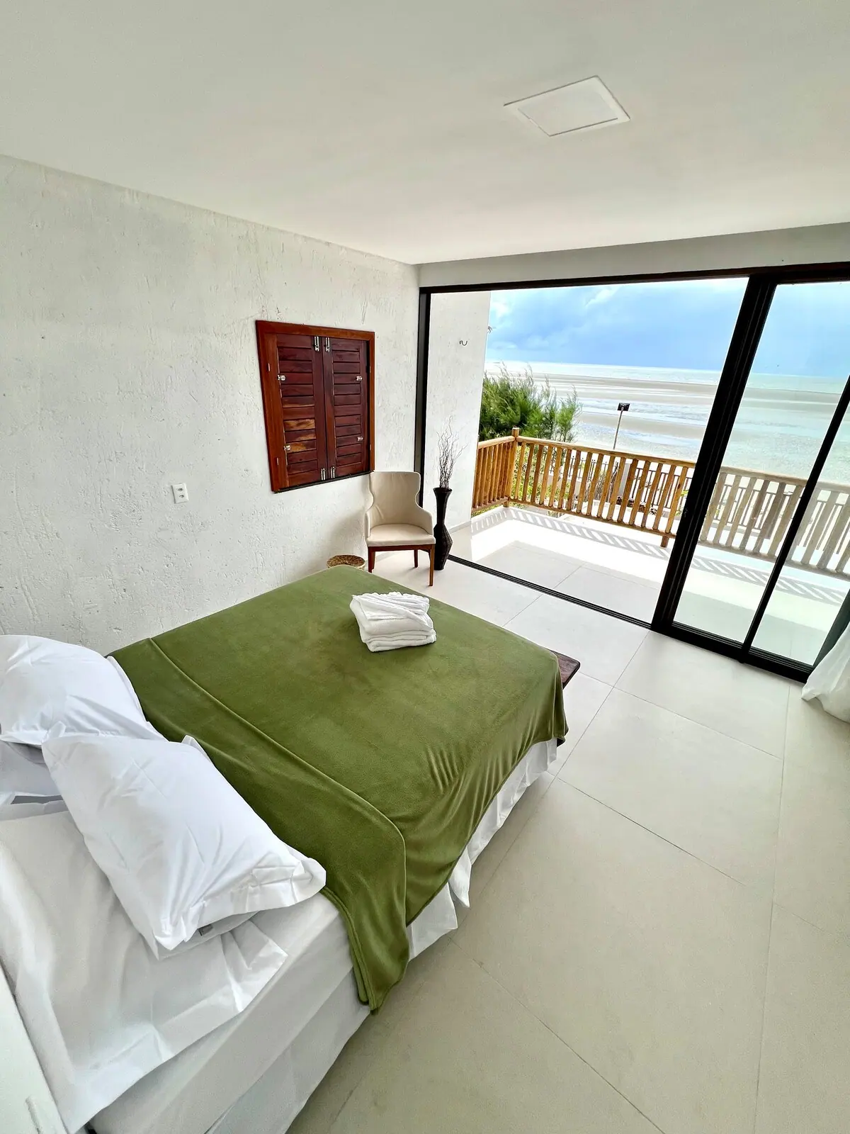 Quarto com varanda de madeira e o mar ao fundo