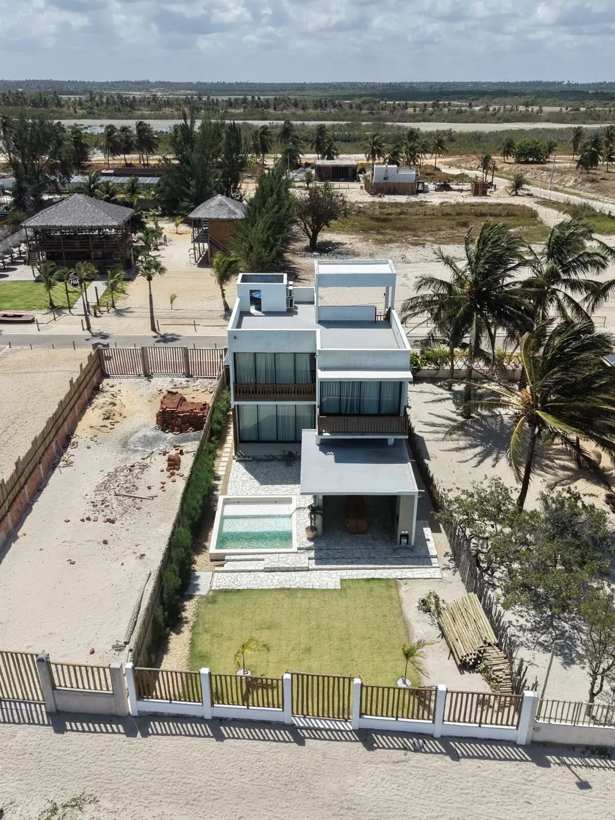 Vista aérea da Casa Ventus, com o gramado e a cerca de bambu voltados para a praia