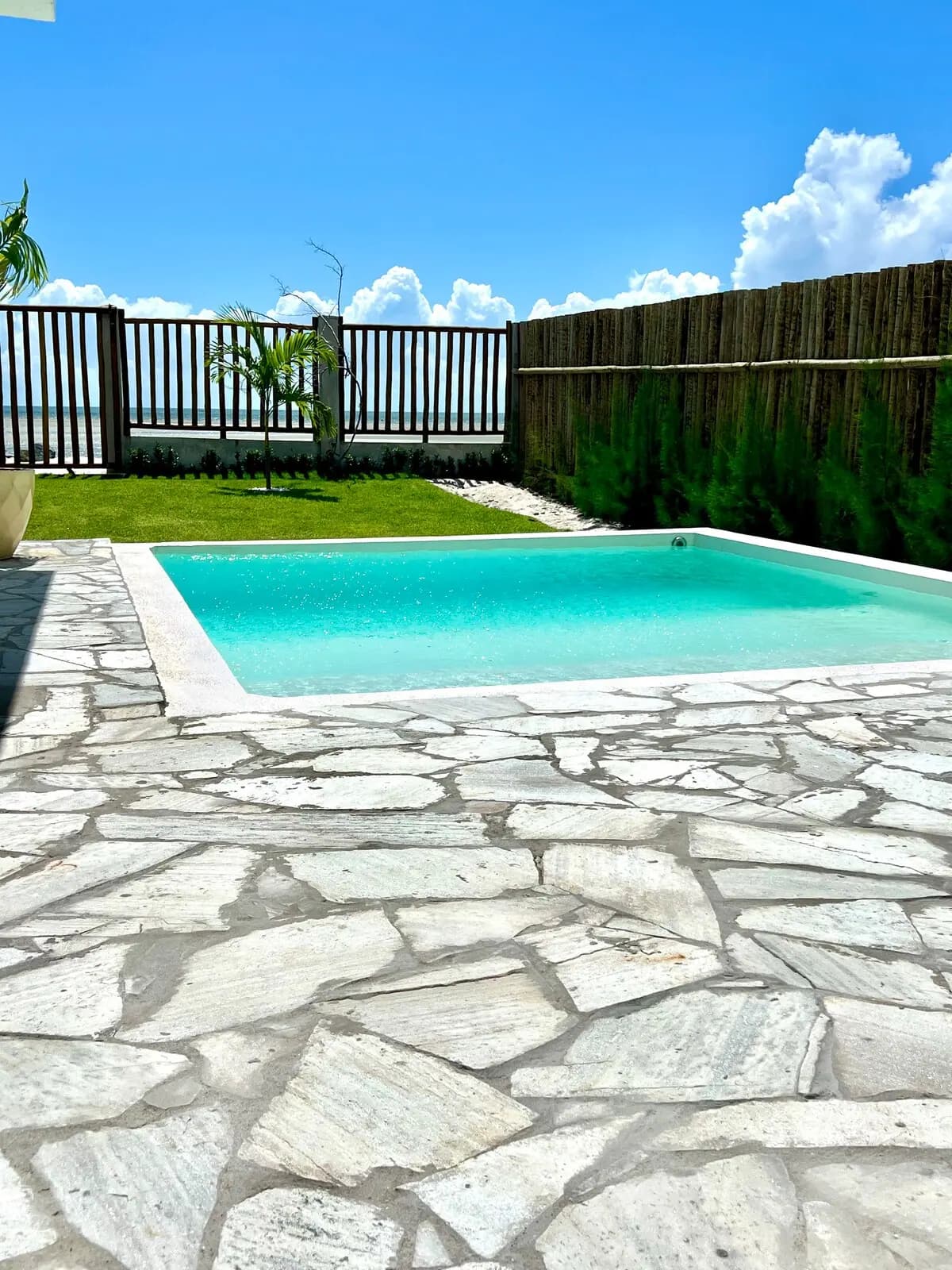 Piscina cercada por piso de pedra clara